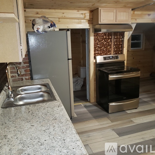 A kitchen with a sink, refrigerator, and stove.