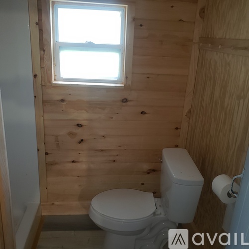 A small bathroom with a toilet and a window.