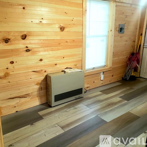 A room with wooden walls and a window with a white frame.