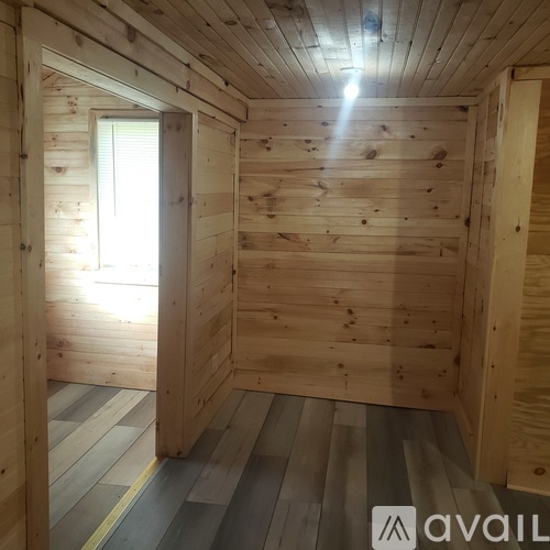 A wooden room with a window and a door.