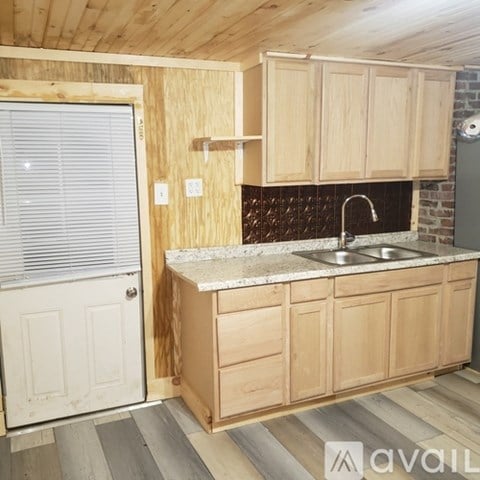 A kitchen with wooden cabinets and a marble countertop.