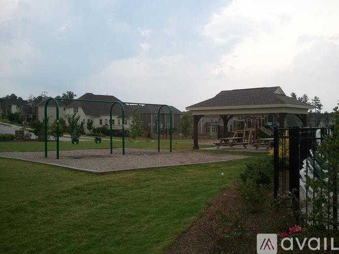 A playground with a swing set and a gazebo-like structure in the background.