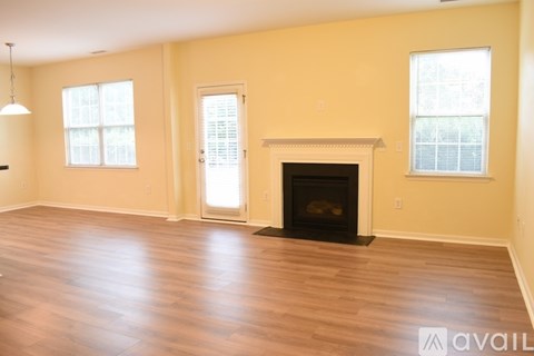 A living room with a fireplace and two windows.
