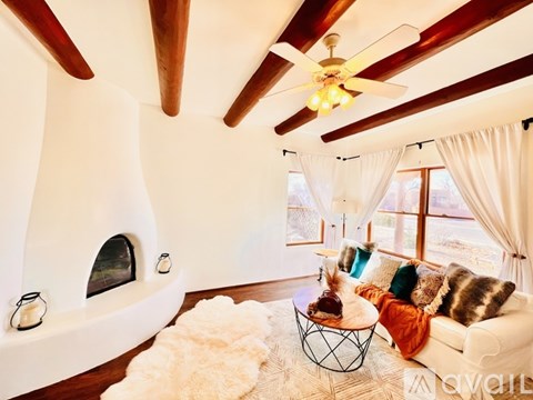 A living room with a white couch and a fireplace.