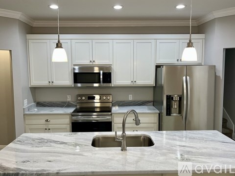 A kitchen with a marble countertop and stainless steel appliances.