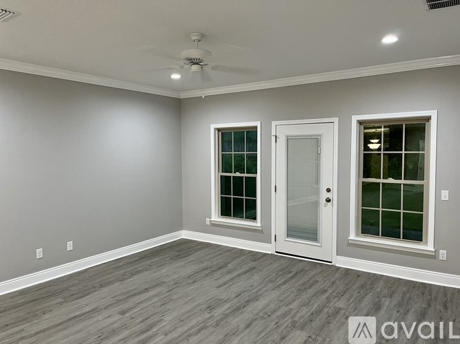 A room with a ceiling fan and two doors with windows.