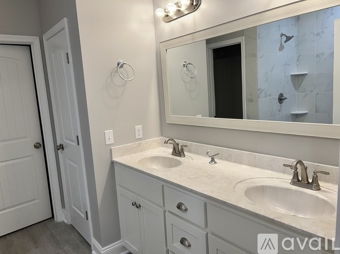 A bathroom with a white sink and a mirror above it.