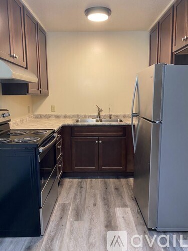 A kitchen with a black oven and a white fridge.
