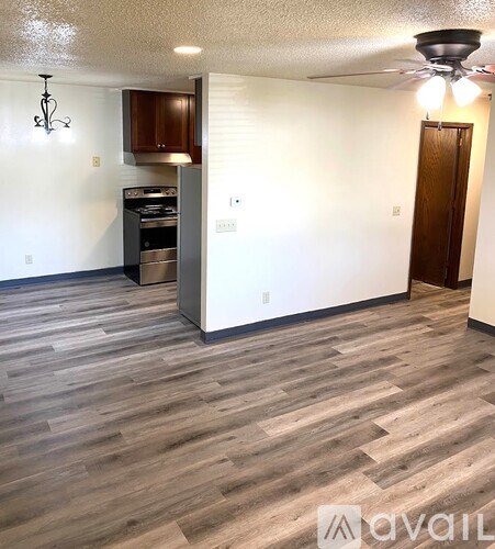A kitchen with a wooden floor and a white wall.