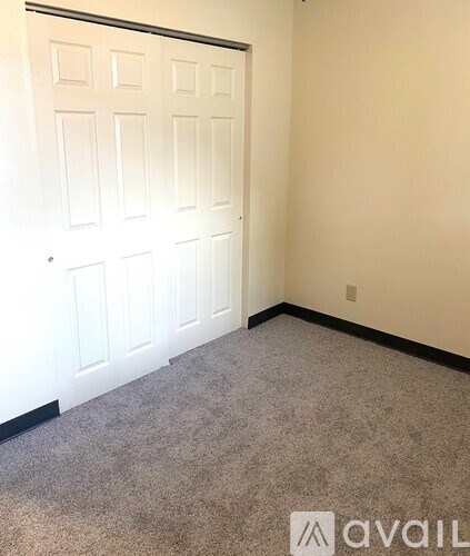A white door in a room with carpeted floor.