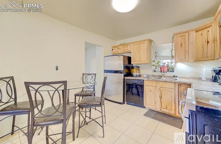 A kitchen with a refrigerator, oven, and sink.