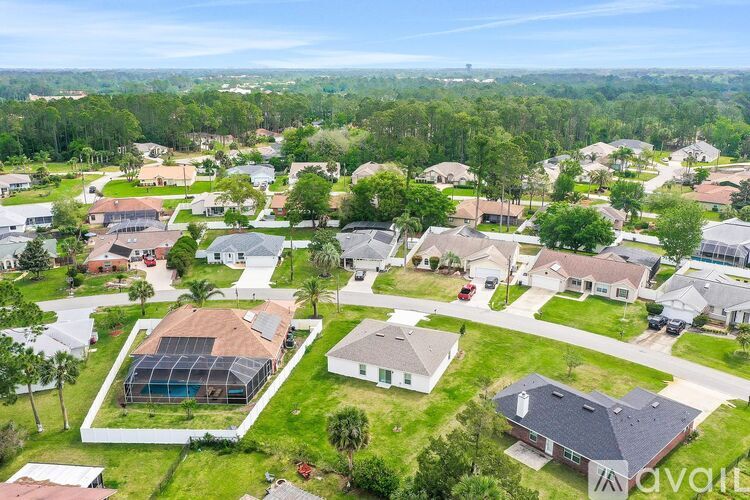 A bird's eye view of a residential neighborhood with houses and a large green space.