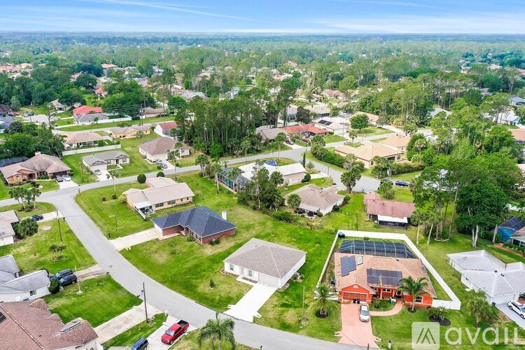 A bird's eye view of a residential area with houses and a large building with a red roof.