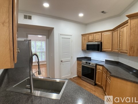 A kitchen with wooden cabinets and a stainless steel sink.