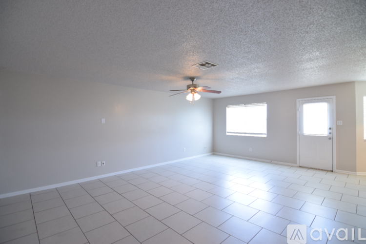 A spacious room with a ceiling fan and tile flooring.