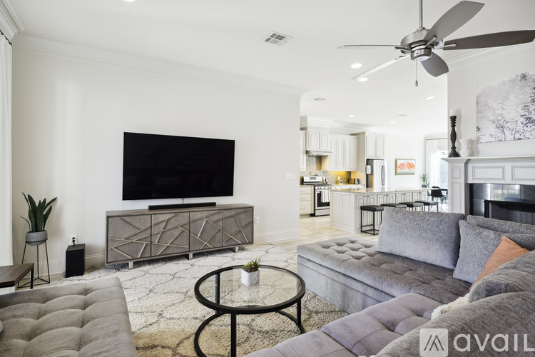 A living room with a grey couch and a black coffee table.