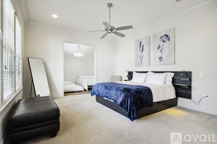 A bedroom with a large bed and a ceiling fan.