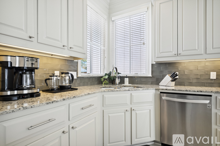 A kitchen with white cabinets and a granite countertop.