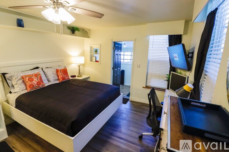 A bedroom with a bed, desk, and chair.