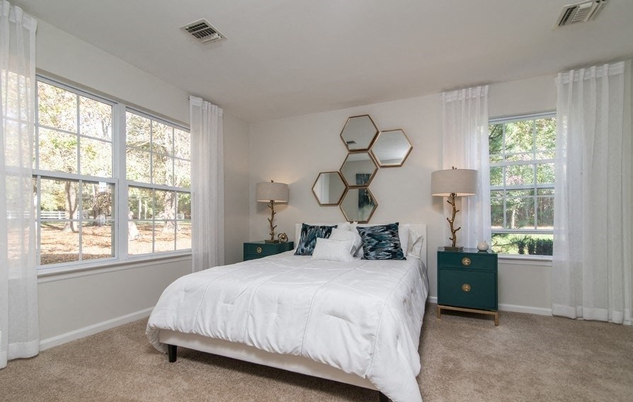 a bedroom with a bed and three windows