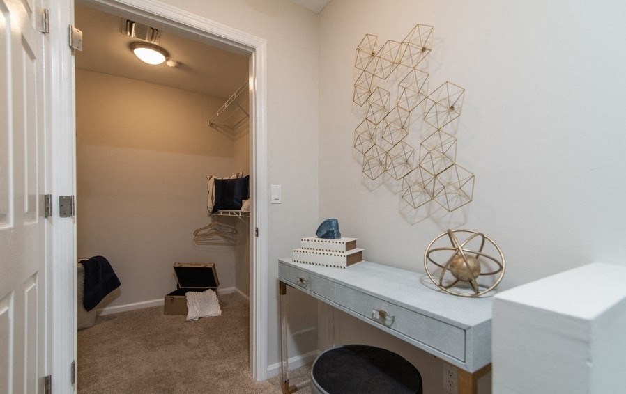 a closet with a desk and a mirror in a house