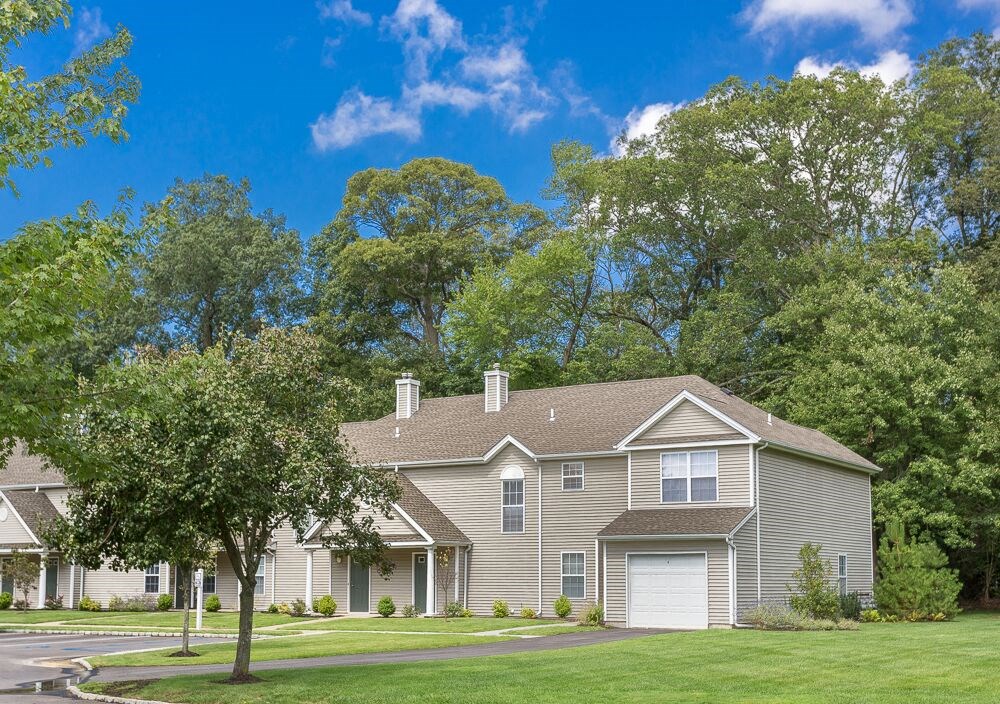 a house with a lawn and trees in front of it