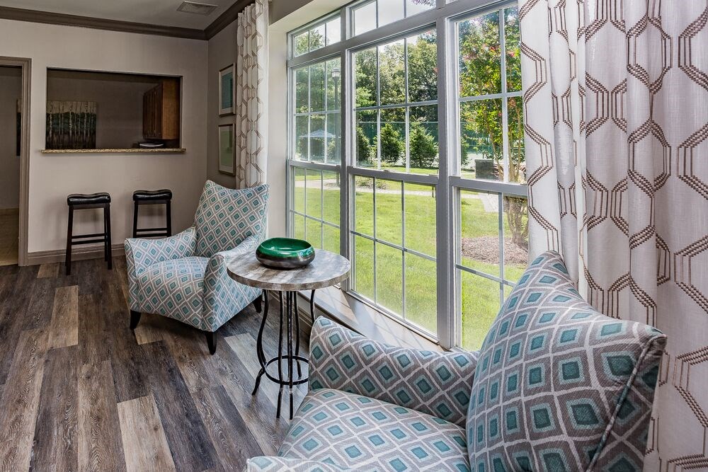 a living room with two chairs and a table and a window