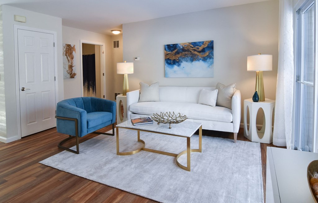 a living room with a white couch and a blue chair