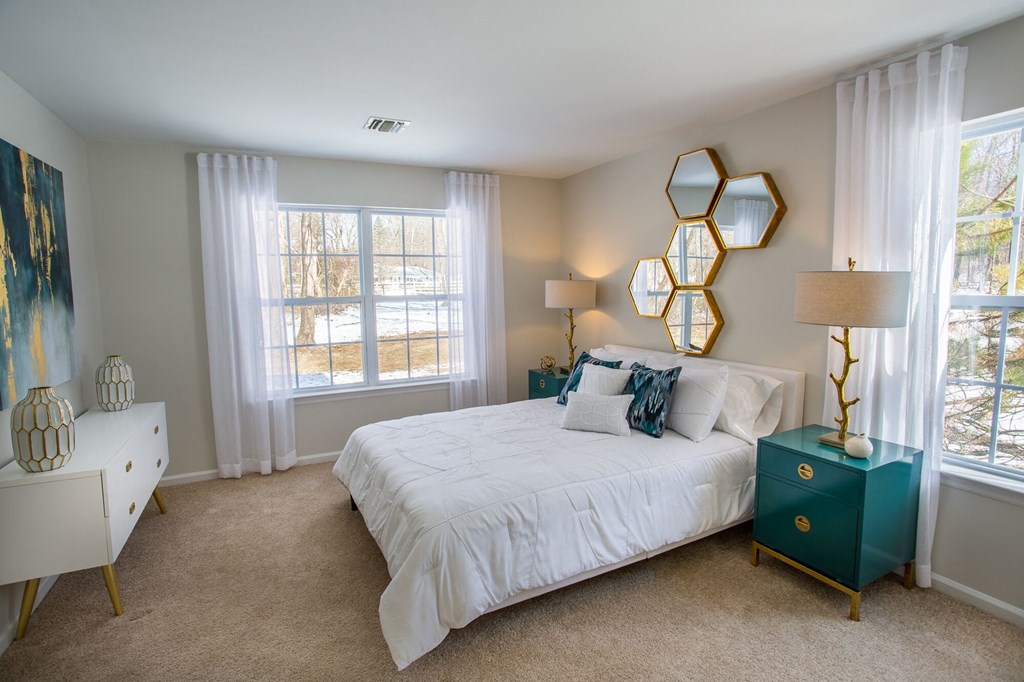 a bedroom with a bed and two windows