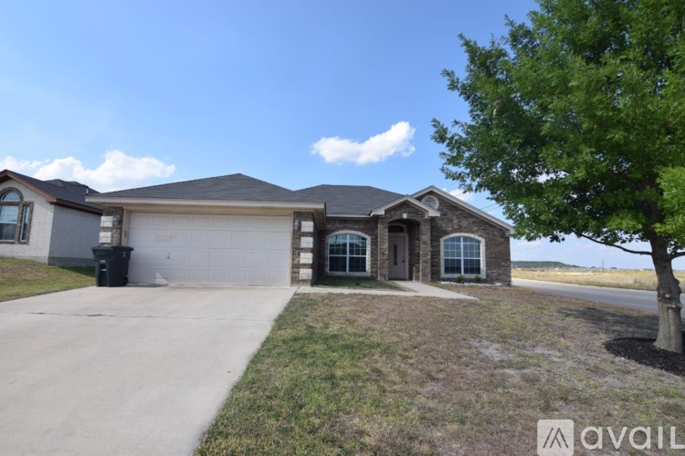 A house with a driveway and a tree in front of it.