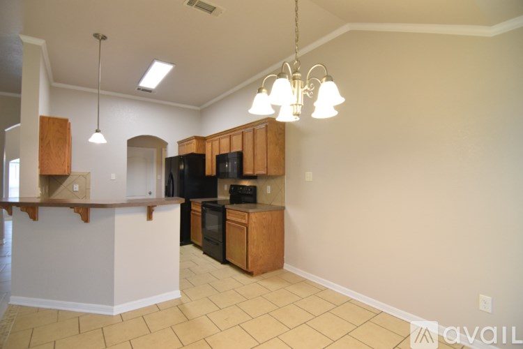 A spacious room with a chandelier and tiled flooring.