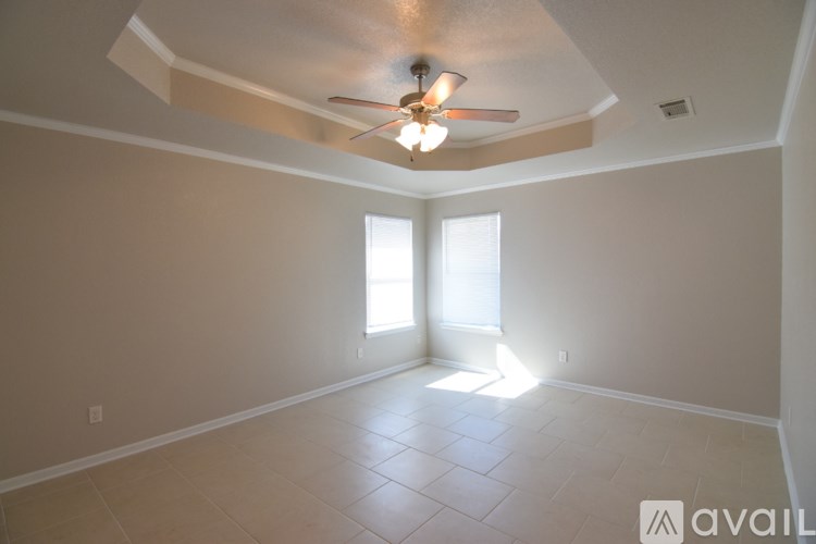 A room with a ceiling fan and two windows.