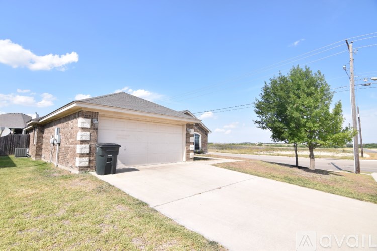 A house with a garage and a tree in front of it.