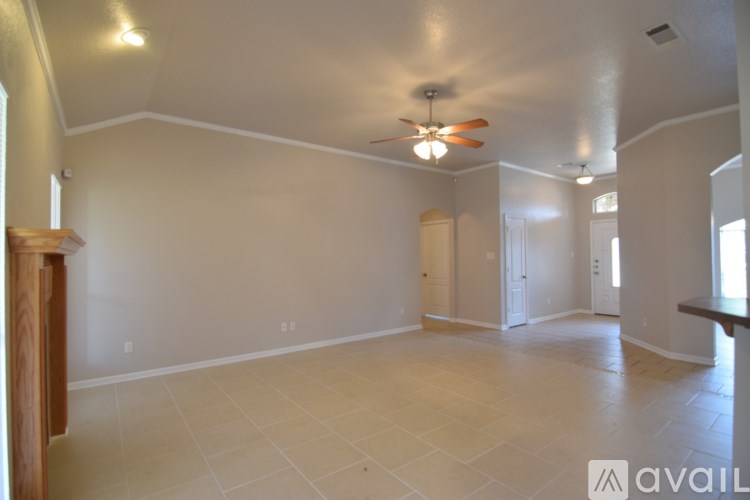 A spacious room with a ceiling fan and tiled flooring.