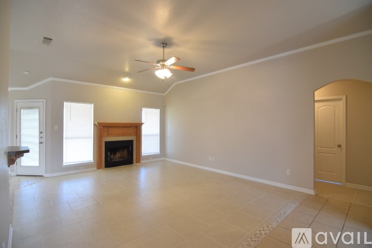 A spacious living room with a fireplace and a ceiling fan.