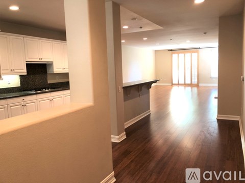 A spacious kitchen with white cabinets and a black countertop.