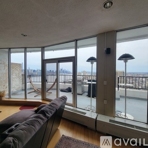 A living room with a large couch and a view of the city.