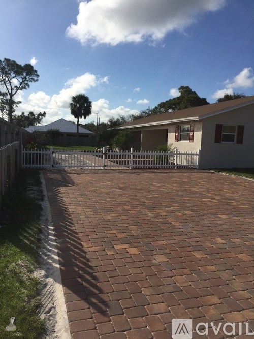 A house with a driveway and a mountain in the background.