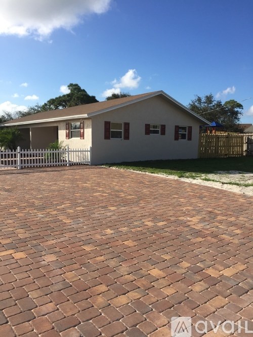 A house with a brick driveway in front.