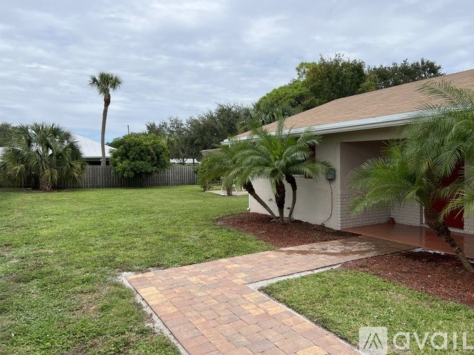 A house with a brick pathway leading to the front door.
