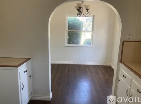 A kitchen with white cabinets and a window.