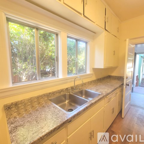A kitchen with granite countertops and white cabinets.