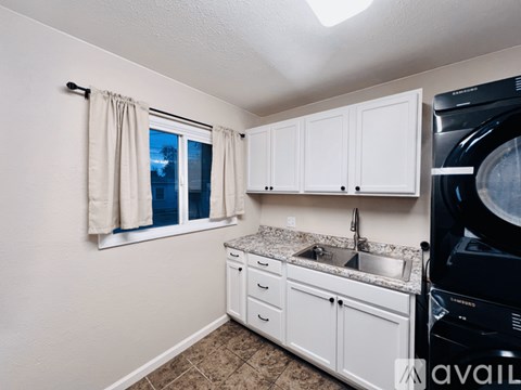 A small kitchen with white cabinets and a black dishwasher.