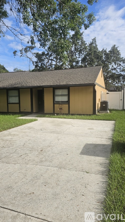 A house with a brown roof and a concrete driveway.