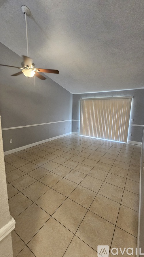 A room with a ceiling fan and tiled floor.