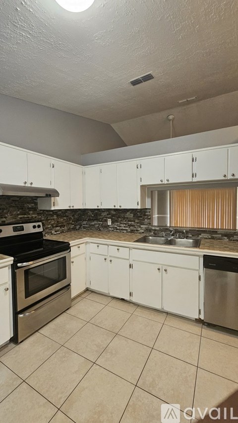 A kitchen with white cabinets and a black stove top oven.