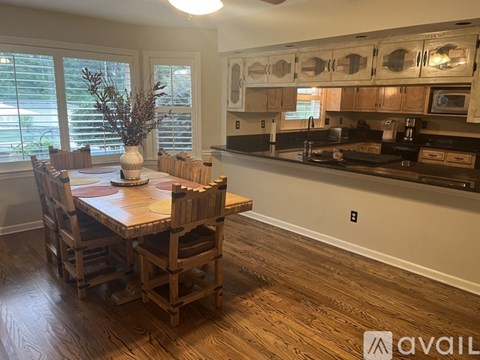 A kitchen with a wooden table and chairs.