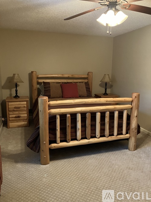 A bedroom with a bed, nightstands, and a ceiling fan.