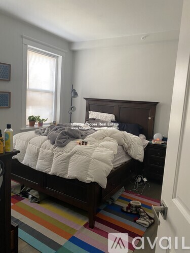 A bedroom with a bed, nightstand, and lamp.