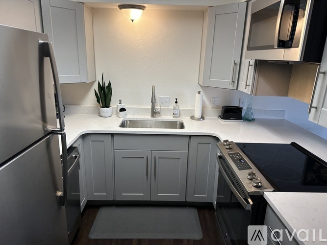 A modern kitchen with a stainless steel refrigerator and a white sink.